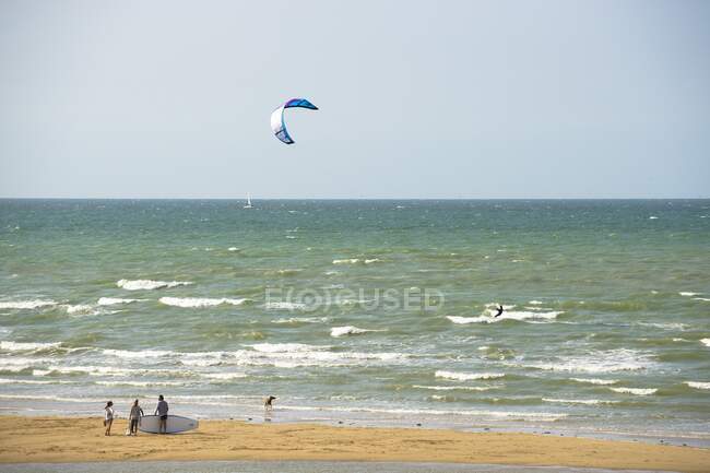 France, Normandy, people enjoying a windy afternoon at the seaside, kite surfing — Stock Photo