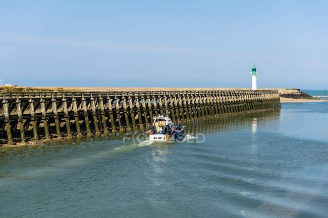 Francia, Normandia, barca che lascia il fiume Touques per il mare in una bella giornata estiva vicino al faro — Foto stock