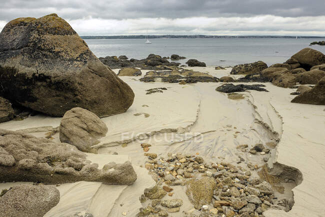 Francia, Bretaña, Finistere, Rocas en la playa de arena Beg-Meil - foto de stock
