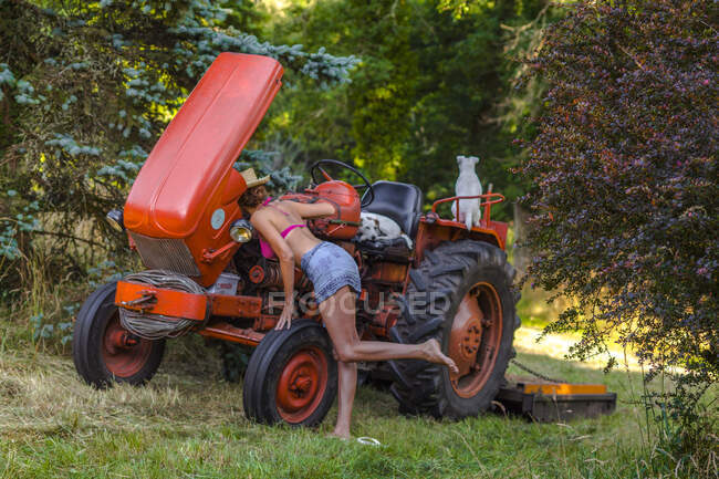 Sexy women looking at the tractor engine — Stock Photo