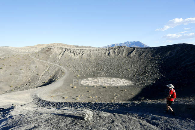 USA. Kalifornien. Death Valley. Ubehebe-Krater. Little Hebe (Vulkankrater nebenan). Wanderer steigt in Patronenhülse. — Stockfoto