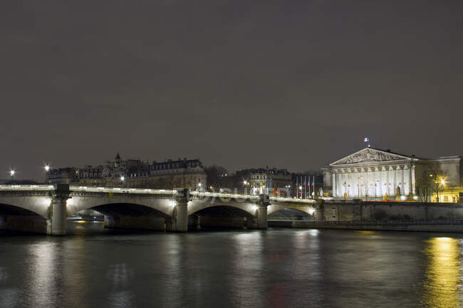 Francia, París, Puente Concorde y Palacio Borbón (Asamblea Nacional), por la noche. - foto de stock