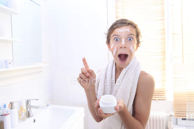 France, young boy in the bathroom, using skin cream. — Stock Photo