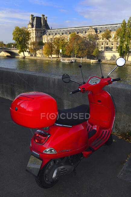 Червоний скутер Європи навпроти музею Лувр у Парижі. — стокове фото