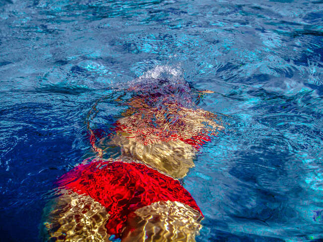 Women in red diving suit in a blue water pool — Stock Photo