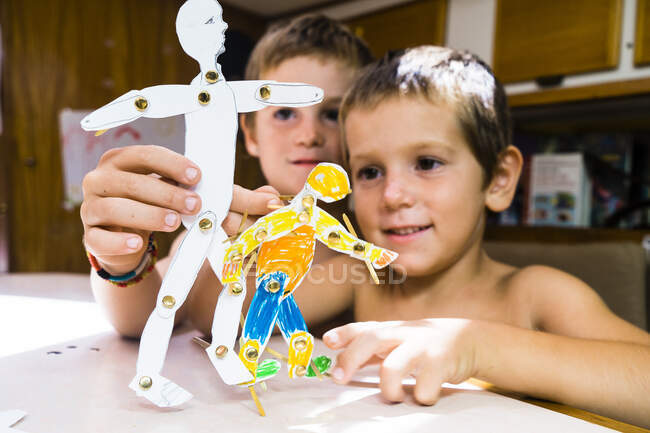 Due bambini che giocano su un tavolo con marionette in carta, Charlotteville, Tobago, Trinidad e Tobago, Indie Occidentali, Sud America — Foto stock