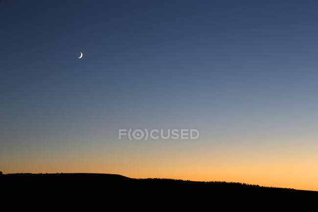 The Massif Central. Cantal. Plateau Trizac. Twilight on the board in the summer. Crescent moon. — Stock Photo