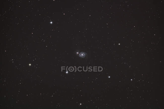 Seine et Marne. En el corazón de la constelación de perros de caza (Canes venatici) una galaxia (M51 - Whirlpool) parece perdida entre las estrellas. - foto de stock