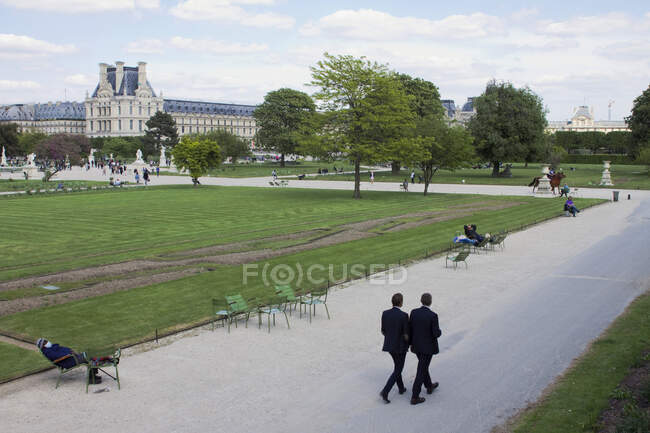 Francia, París, departamento 75, primer distrito, dos ejecutivos caminando por el Jardín de las Tullerías. - foto de stock