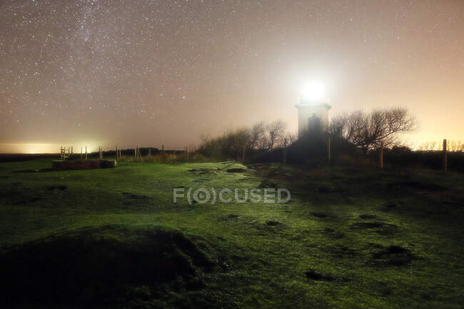 Normandía. Manche. Pointe d'Agon Coutainville. El semáforo en la noche, bajo las estrellas. - foto de stock