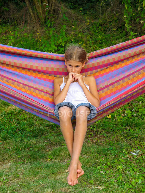 Thoughtful girl swinging in a hammock in the country. — Stock Photo