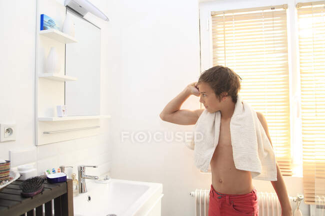 Frankreich, kleiner Junge im Badezimmer schaut in den Spiegel. — Stockfoto