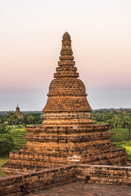 Myanmar, zona de Mandalay, sitio arqueológico de Bagan entre árboles verdes - foto de stock