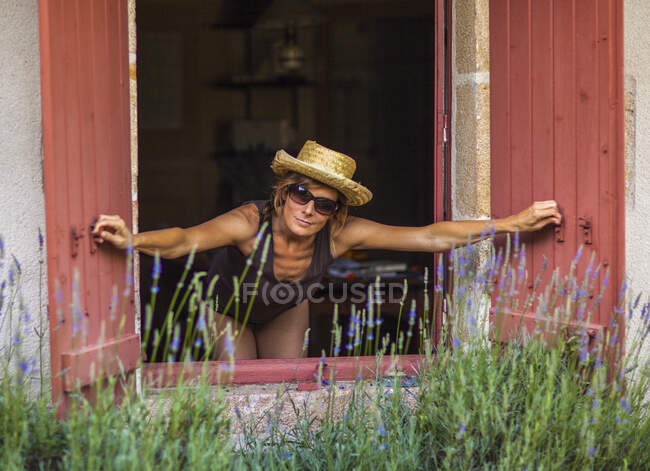 Youg women opening shutters  in the countryside — Stock Photo