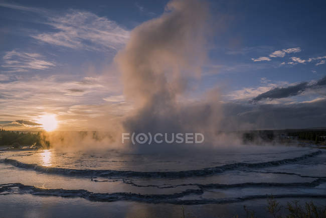 Splashing geyser at sunset, Yellowstone National Park, Wyoming, Estados Unidos de América, Norteamérica - foto de stock