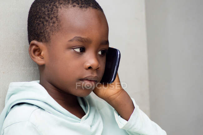 Kind hörte mit großer Aufmerksamkeit zu, dass seine Mutter ihm am Telefon erzählte. — Stockfoto