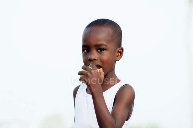 Il bambino mangia una mela siccome è nutriente . — Foto stock