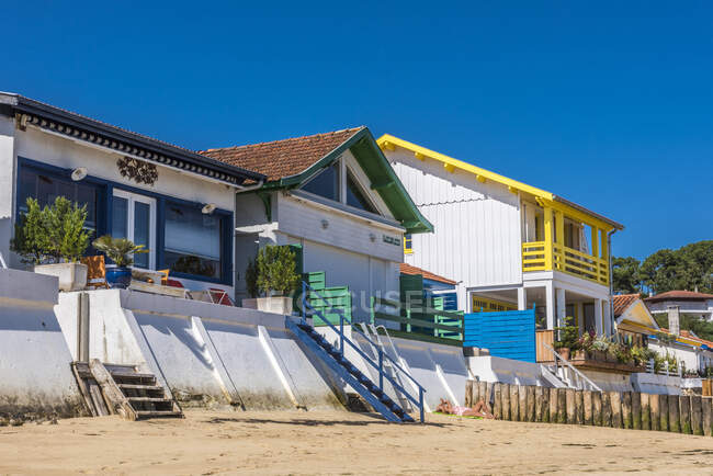 Francia, Gironda, Bahía Arcachon, Cap-Ferret, pueblo de L 'Herbe, casas a lo largo de la playa y barreras contra inundaciones. - foto de stock