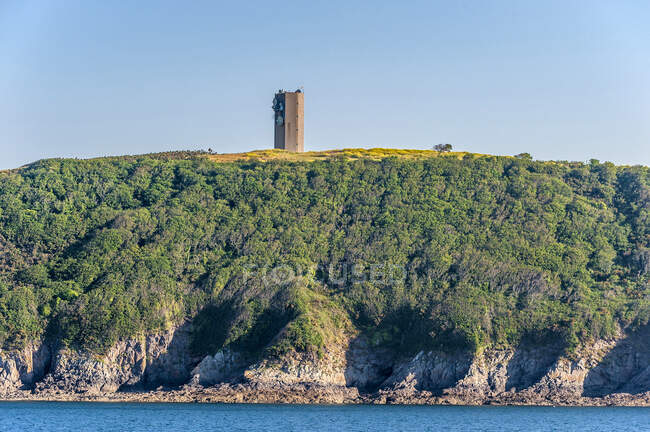 Francia, Bretaña, Goulet de Brest, Plouzane, torre de telecomunicaciones en el borde de los acantilados - foto de stock