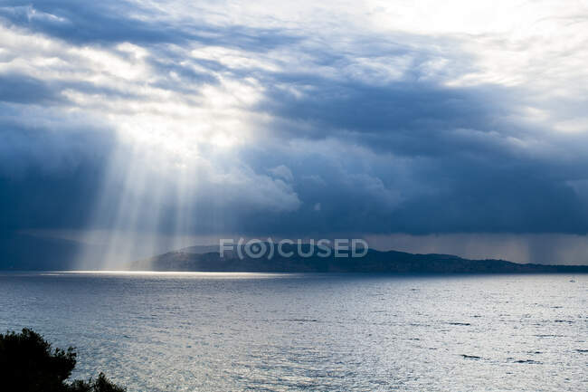 Grecia, Corfú, vista de la costa albanesa bañada por los rayos del sol después de la tormenta. Costa de Albania visible desde Corfú, Grecia - foto de stock
