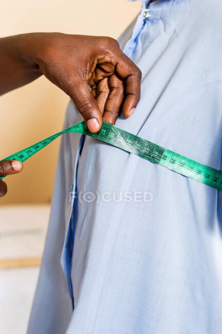 Africano americana costureira medindo peito de um manequim em uma loja. — Fotografia de Stock
