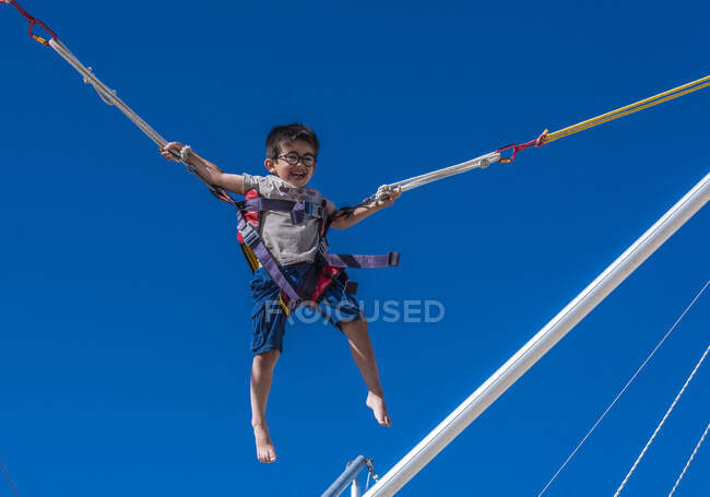 Пятилетний мальчик, прыгающий на батуте — стоковое фото