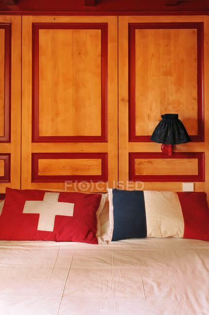 Switzerland, Vaud, La Cure village, the Arbez hotel located on the exact border between French city of Les Rousses and Swiss city of Saint-Cergues. Close up on two pillows with the French and Swiss flags — Stock Photo