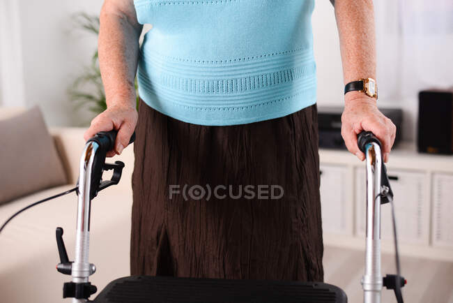 Close up hands shot of elderly senior woman using walker rehab indoor — Stock Photo