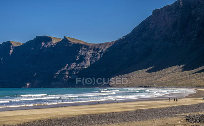 España, Islas Canarias, Isla Lanzarote, playa al pie de las montañas de Caleta de Famara - foto de stock