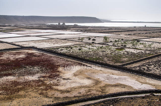 Espanha, Ilhas Canárias, Ilha Lanzarote, fabricação de sal Janubio pelo mar — Fotografia de Stock