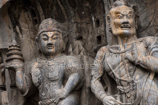 Numerosas estatuas Bouddha en cuevas Longmen, Luoyang, Henan, China - foto de stock