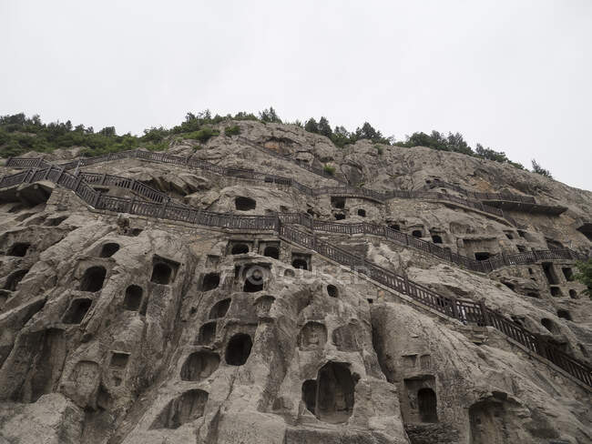 Numerosas estatuas Bouddha en cuevas Longmen, Luoyang, Henan, China - foto de stock