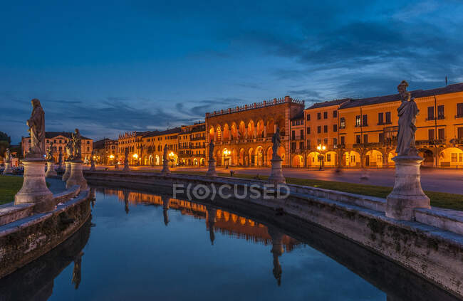 Italia, Véneto, Padua, Prato Della Valle (siglo XVIII), Loggia Amulea (siglo XVII) y estatuas de hombres famosos de Padua a lo largo del canal - foto de stock