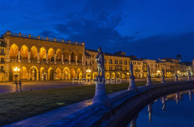 Italia, Véneto, Padua, Prato Della Valle (siglo XVIII), Loggia Amulea (siglo XVII) y estatuas de hombres famosos de Padua a lo largo del canal - foto de stock