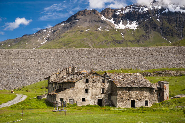 Frankreich, Savoyen, Kühe und verlassener Bauernhof auf den Almen am Fuße der Berge und Gletscher des Mont Cenis — Stockfoto