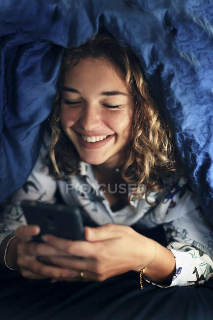 Adolescente et la vie quotidienne. Au lit avec smartphone — Photo de stock
