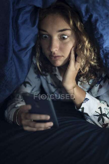 Teenager-Mädchen und der Alltag. Mit Smartphone im Bett — Stockfoto