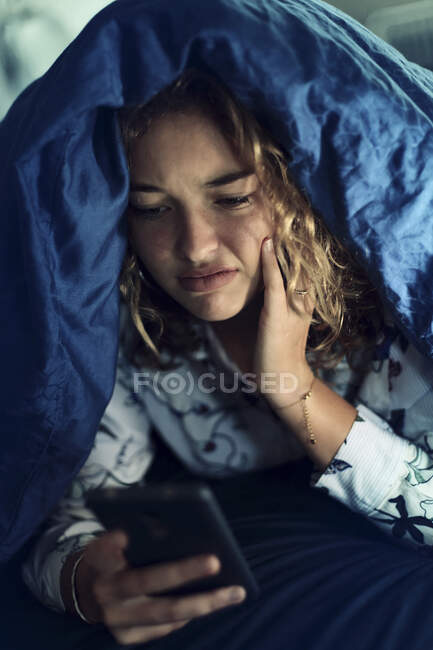 Ragazza adolescente e la vita di tutti i giorni. A letto con smartphone — Foto stock