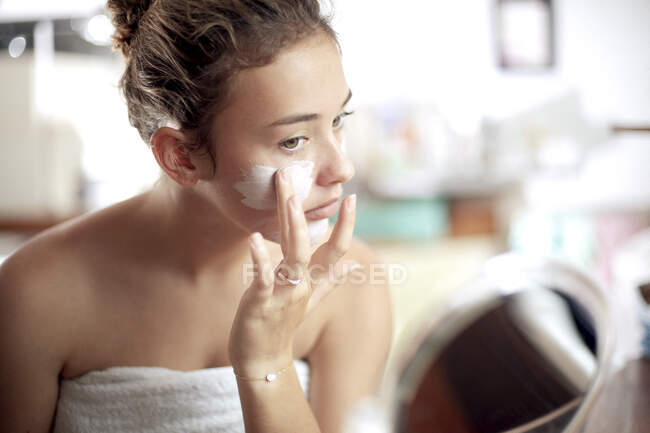 Дівчинка - підліток з масками обличчя у ванній кімнаті. — стокове фото
