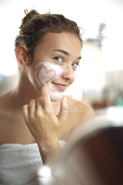 Adolescente avec masque facial dans la salle de bain — Photo de stock
