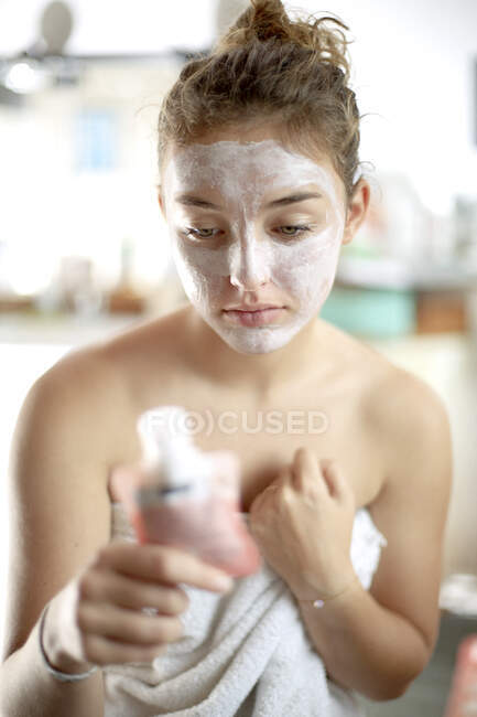 Дівчина-підліток з маскою для обличчя у ванній — стокове фото