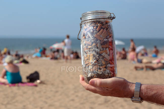 Francia, Saint Michel Chef Chef, frasco que contiene colillas recogidas en la playa. - foto de stock
