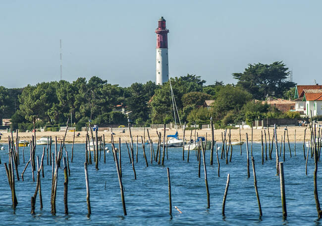 France, Arcachon bay, Cap Ferret peninsula, lighthouse and pinnacles delimiting the oyster farms at high tide — Stock Photo