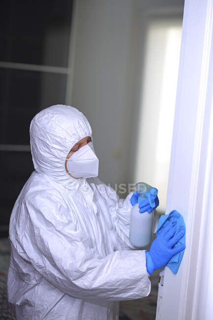 La vie quotidienne pendant l'épidémie de coronavirus, femme nettoyant la maison masquée — Photo de stock