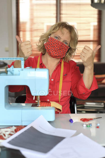 Fabricar trabajadora haciendo máscaras protectoras durante la pandemia del Coronavirus, Covid-19 - foto de stock