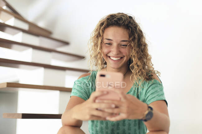 Jovem adolescente em casa com um smartphone. Selfie... — Fotografia de Stock