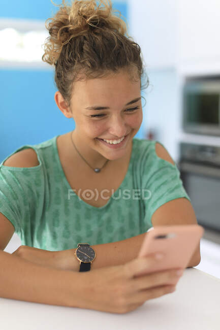 Jovem adolescente em casa com um smartphone — Fotografia de Stock