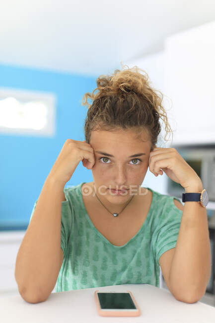 Young teenager at home with a smartphone — Stock Photo