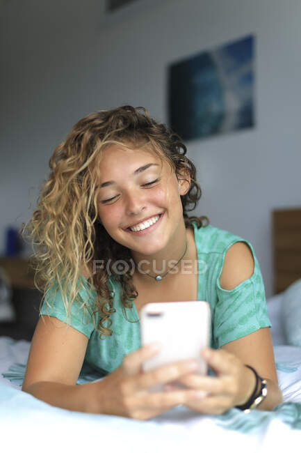 Jeune adolescent à la maison avec un smartphone — Photo de stock
