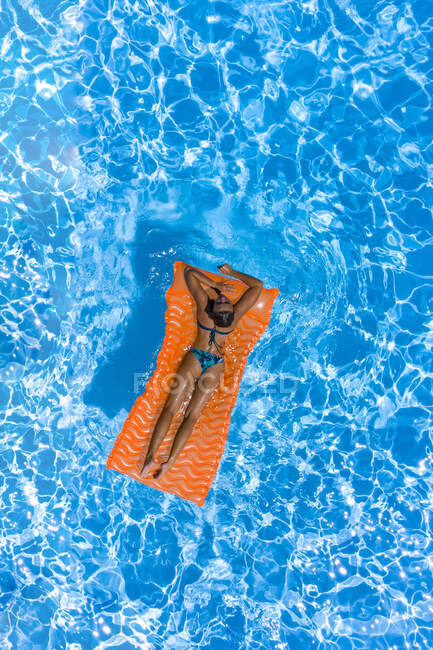 Femme sur un matelas gonflable dans une piscine — Photo de stock
